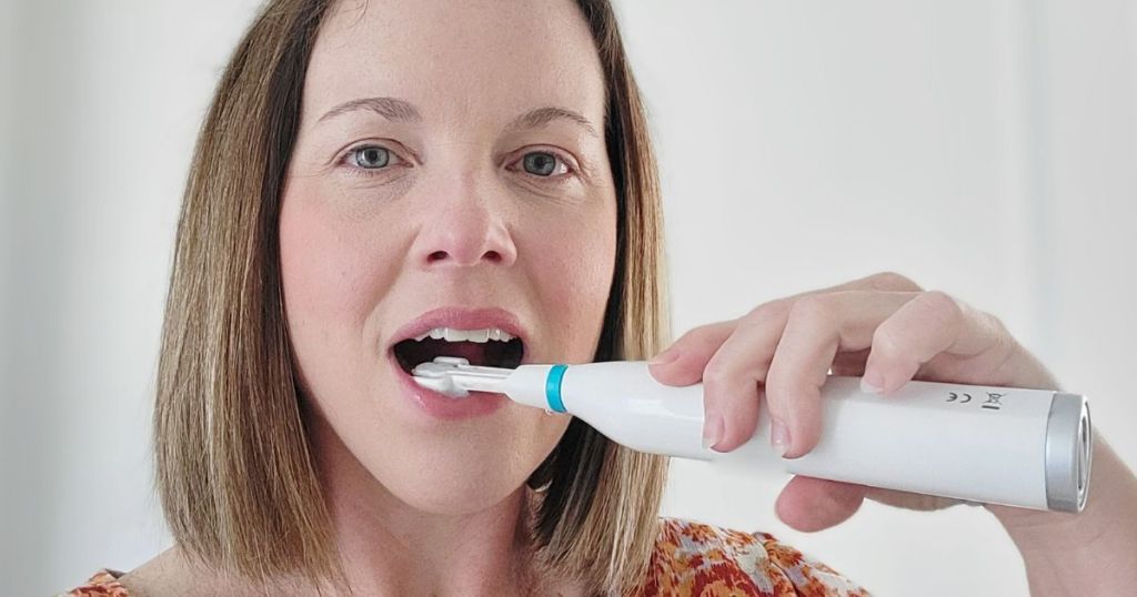 woman using a Triple Bristle Electric Toothbrush