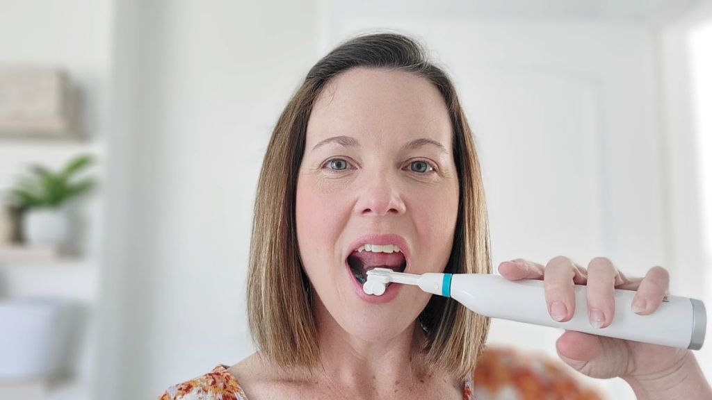 woman using a Triple Bristle Sonic Toothbrush