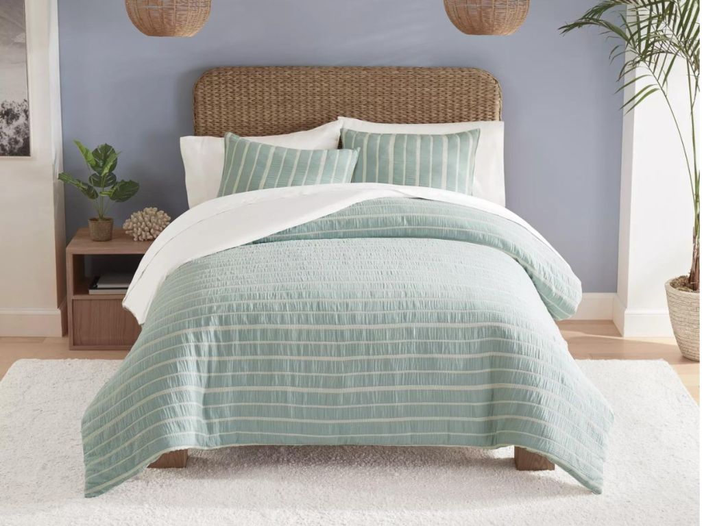 white and mint green striped comforter on bed