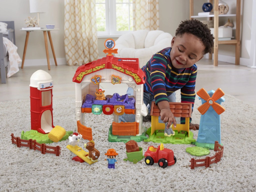 boy playing with farm playset on living room floor