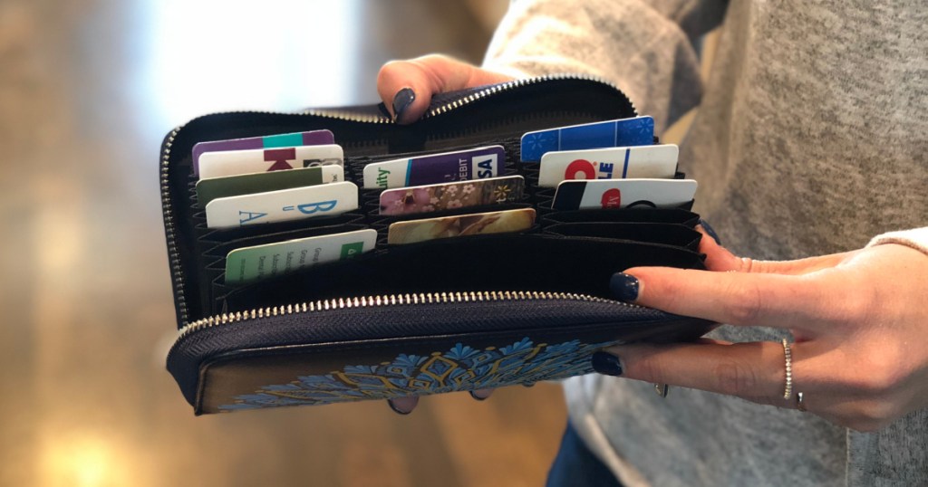 woman holding open wallet full of credit cards