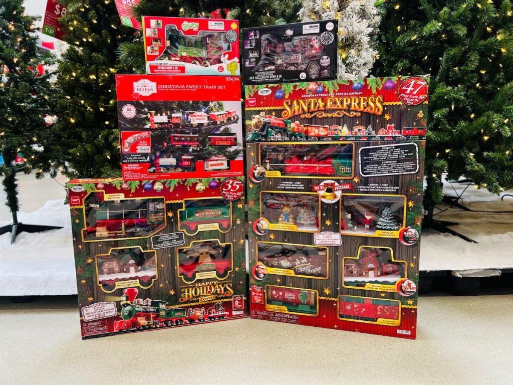 Several boxes of Walmart Train Sets in front of a tree