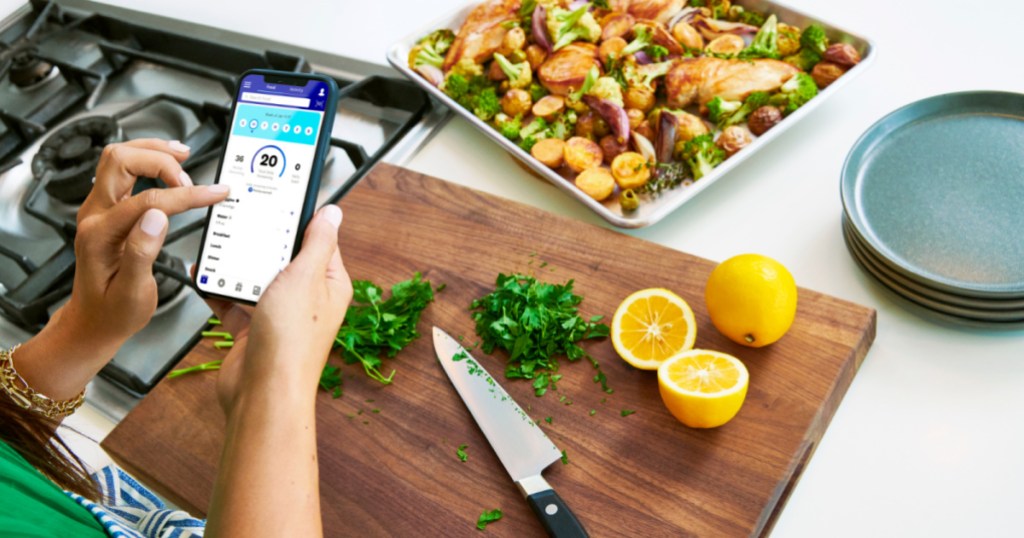 woman using WeightWatchers app while cooking