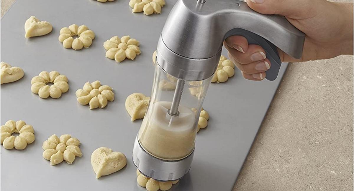 Wilton Cookie Press being used to make spritz cookies on a cookie sheet