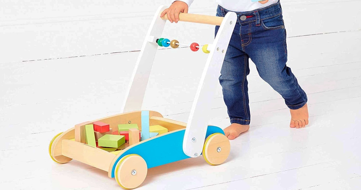 small child pushing a Wooden toddler push truck 
