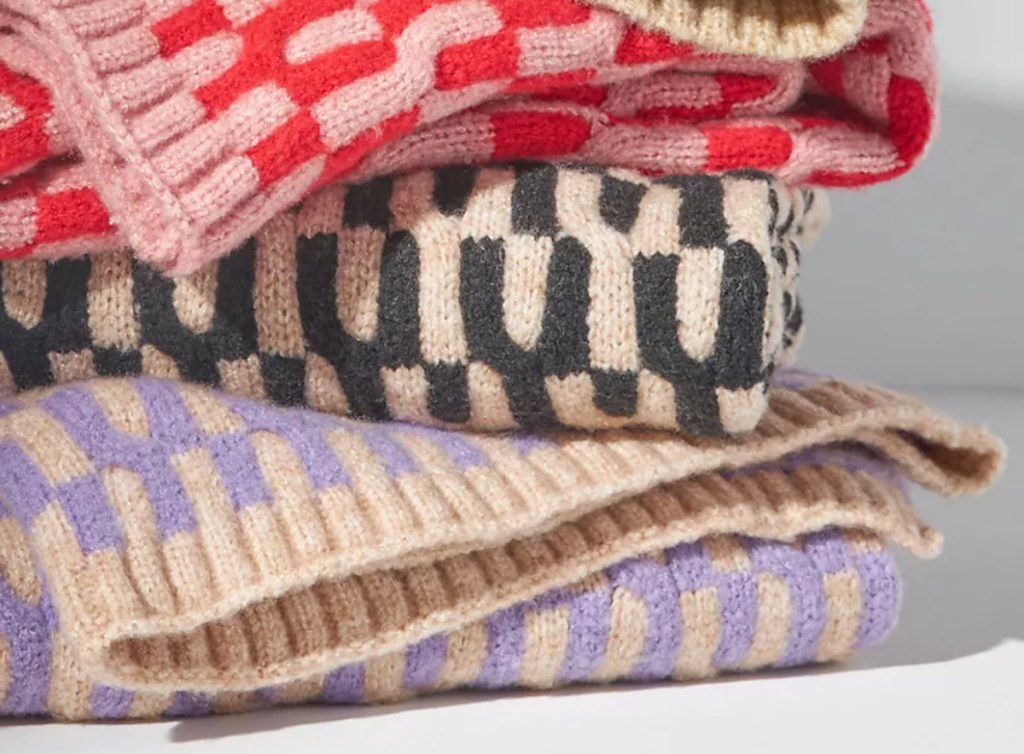 stack of knit blankets with colorful yarn
