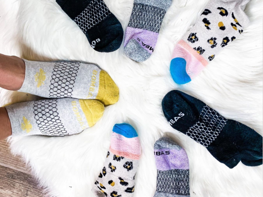 Various pairs of Bombas socks on white blanket