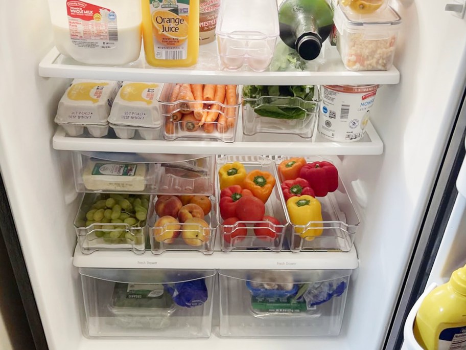 refrigerator full of clear bins with fruits, veggies and other foods inside them 