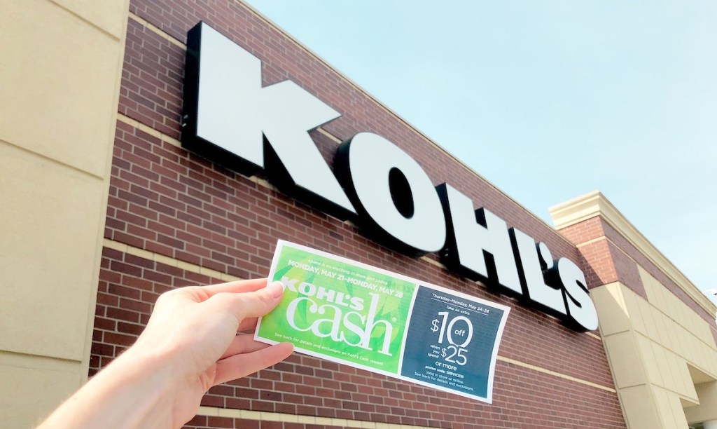 hand holding kohl's cash in front of storefront