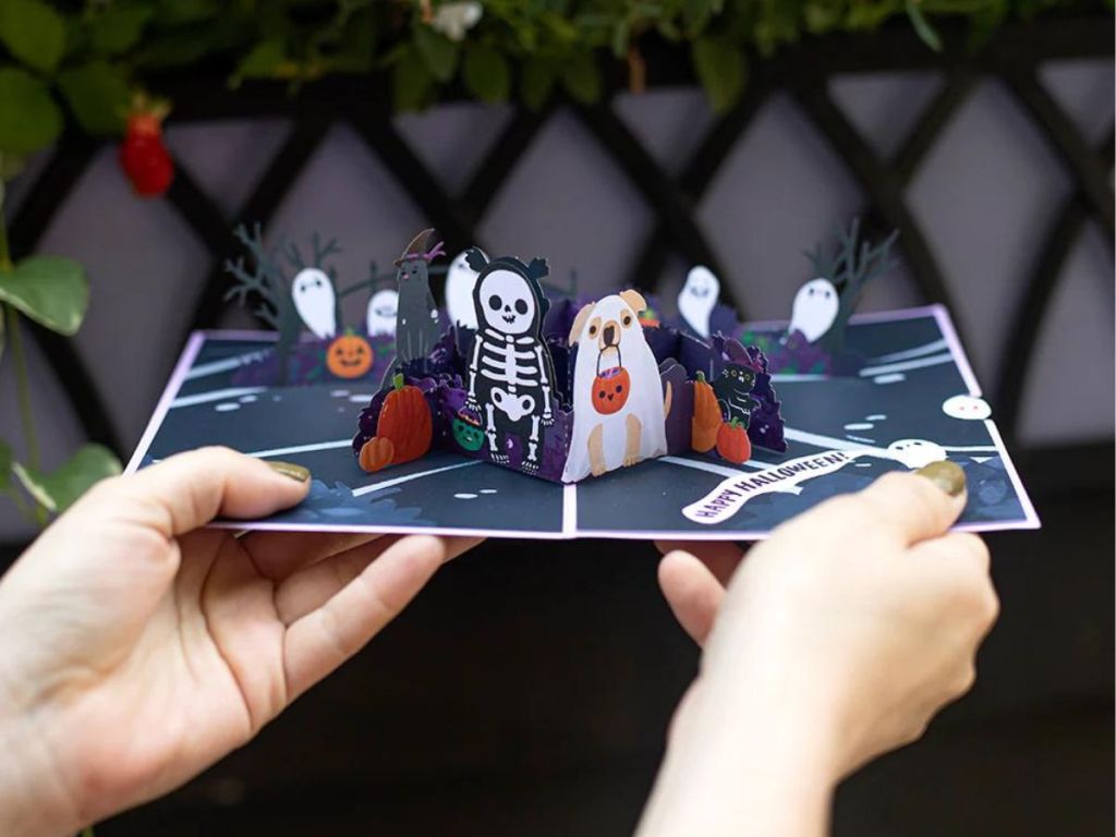 person holding card with halloween figures