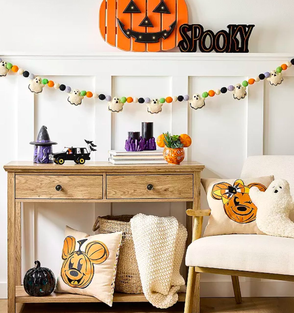 mickey mouse pillows on a chair and spooky led neon sign decorating a halloween scene