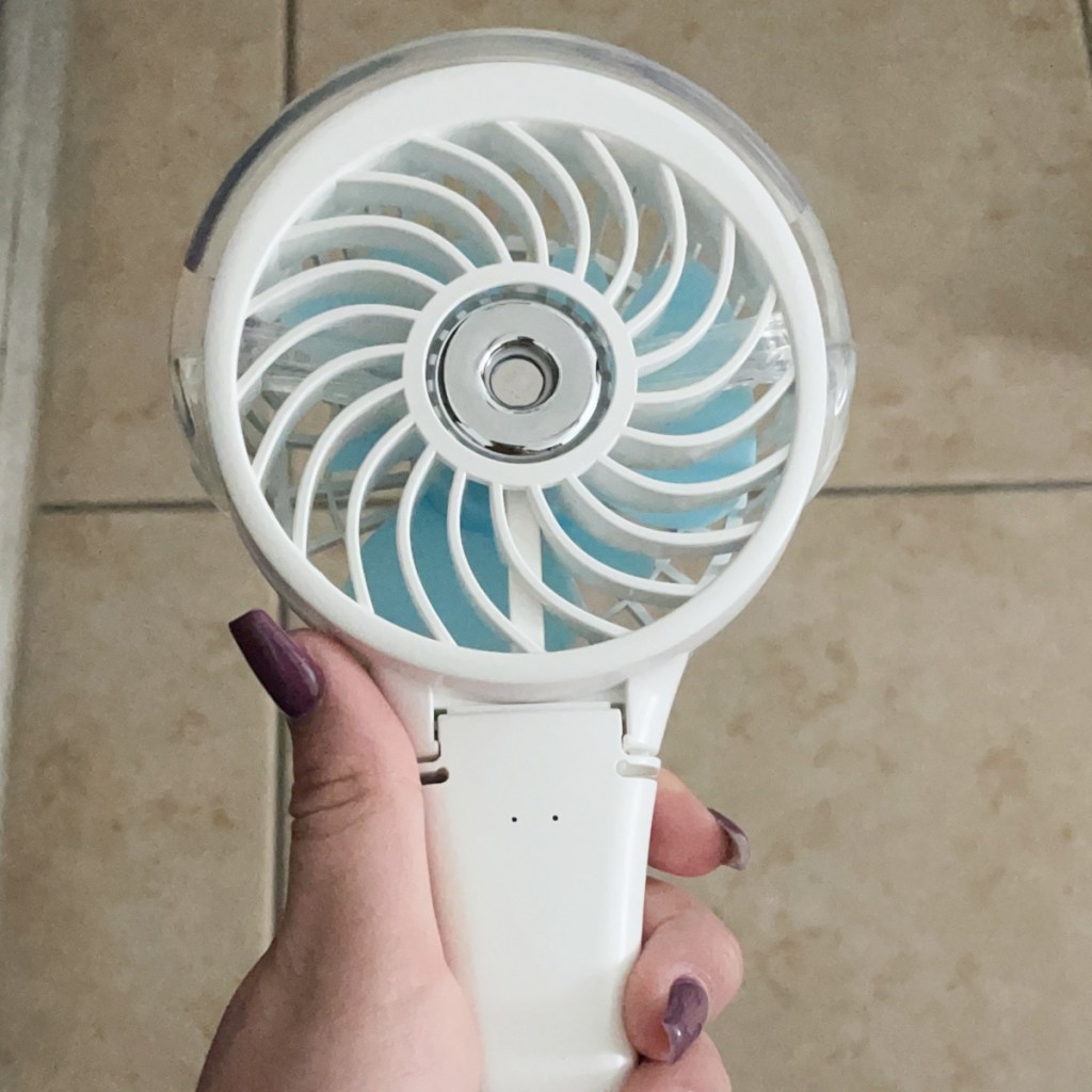 holding a handheld misting fan
