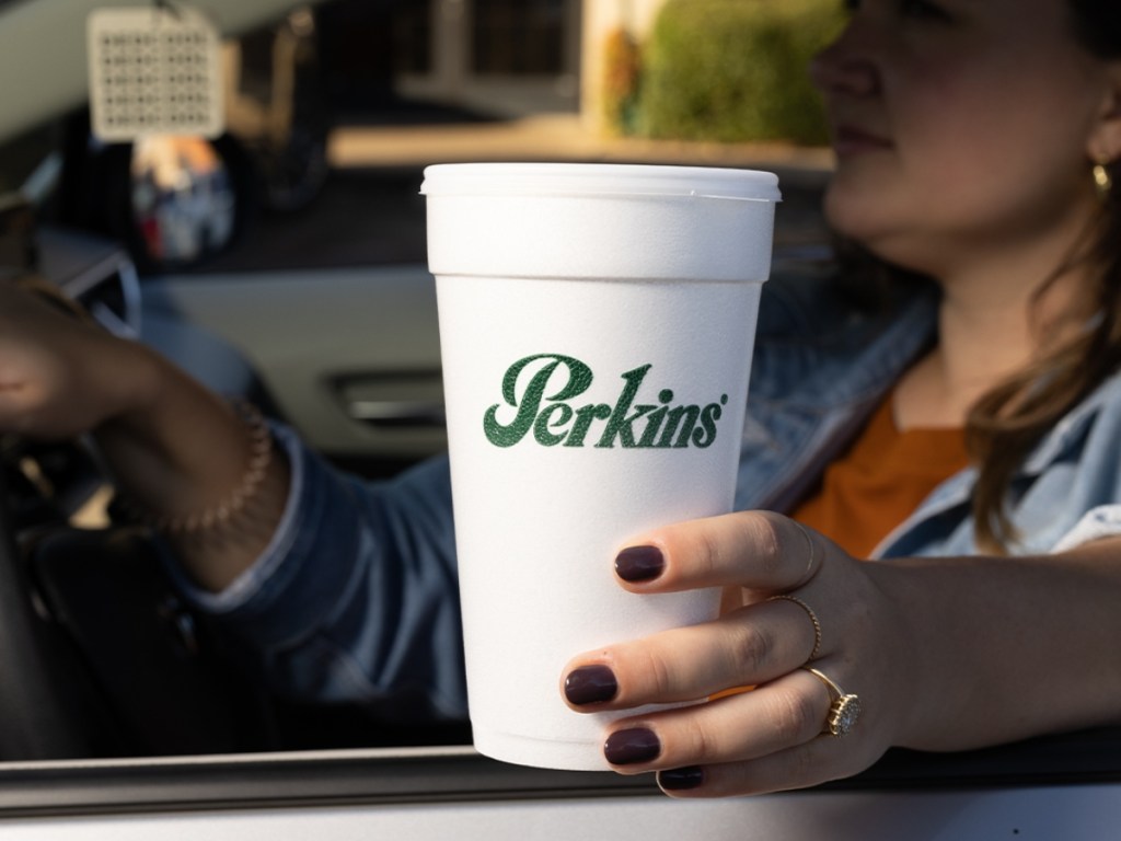 holding coffee in a Perkins to-go cup