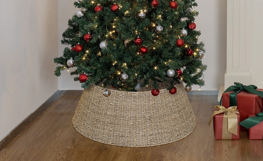 a woven christmas tree skirt around the base of a decorated christmas tree