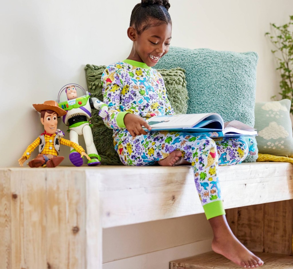 girl in disney pajamas reading book