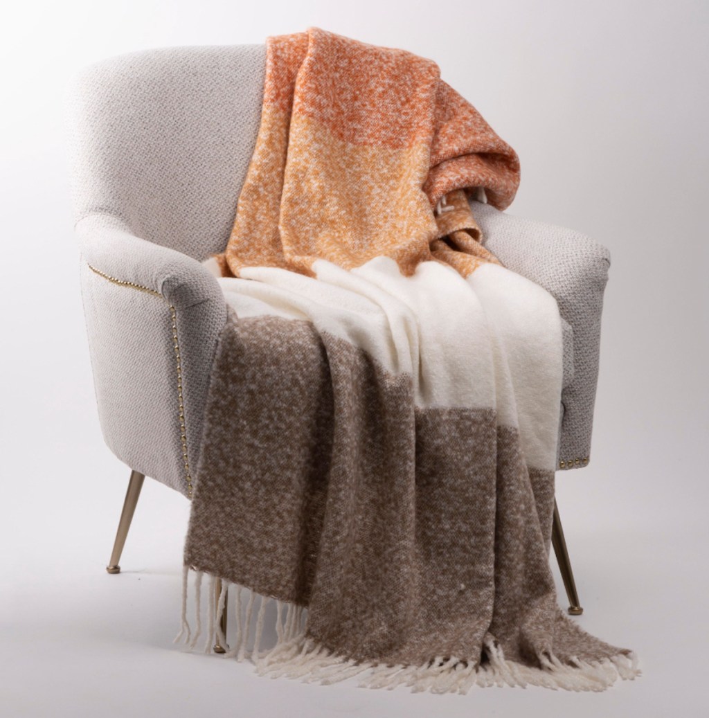 brown cream and orange fleece throw blanket on chair in empty space