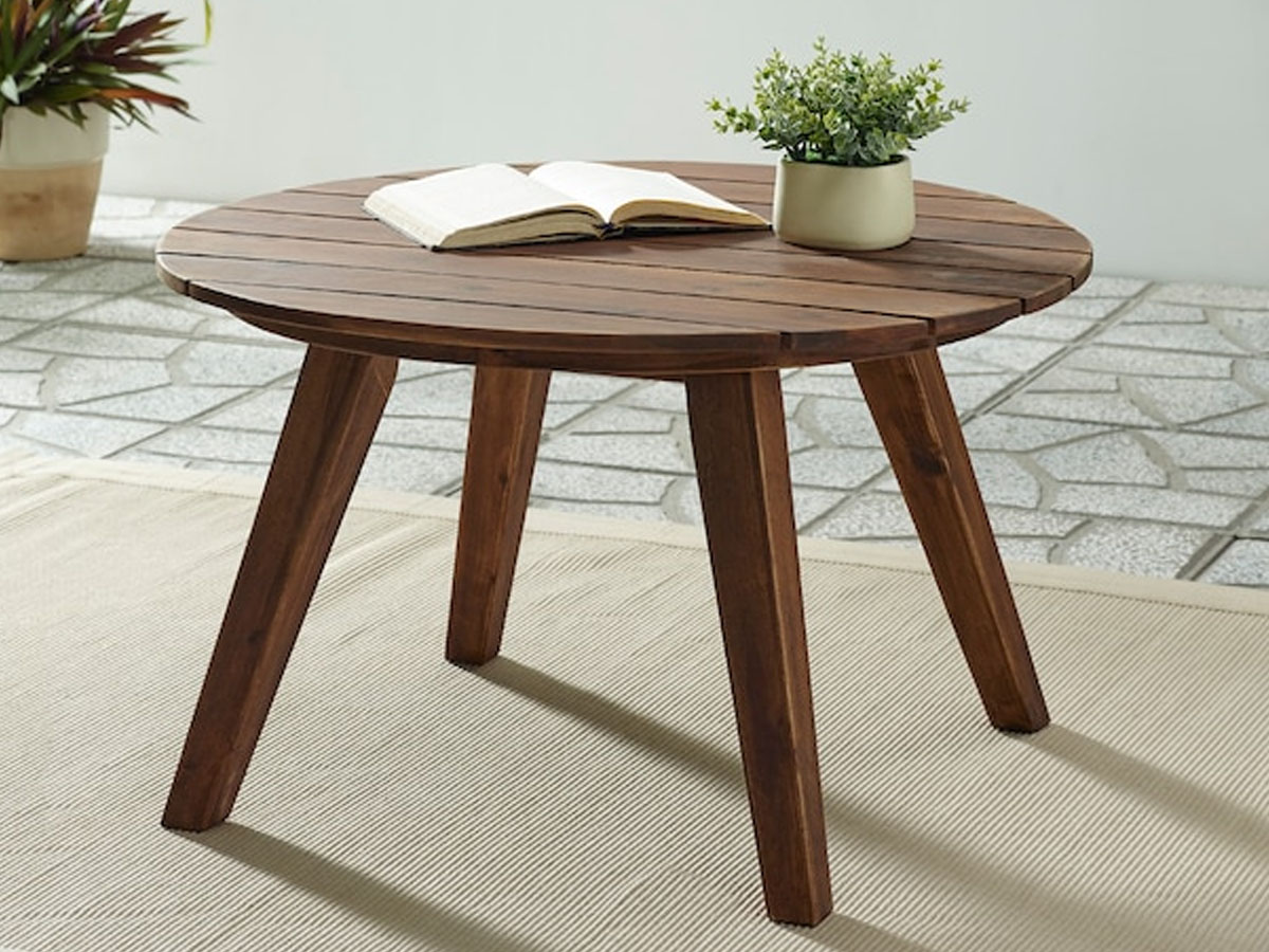 walker edison outdoor coffee table with a book and potted plant on the surface