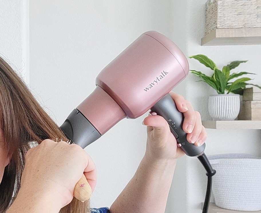 hand holding hair dryer and drying hair