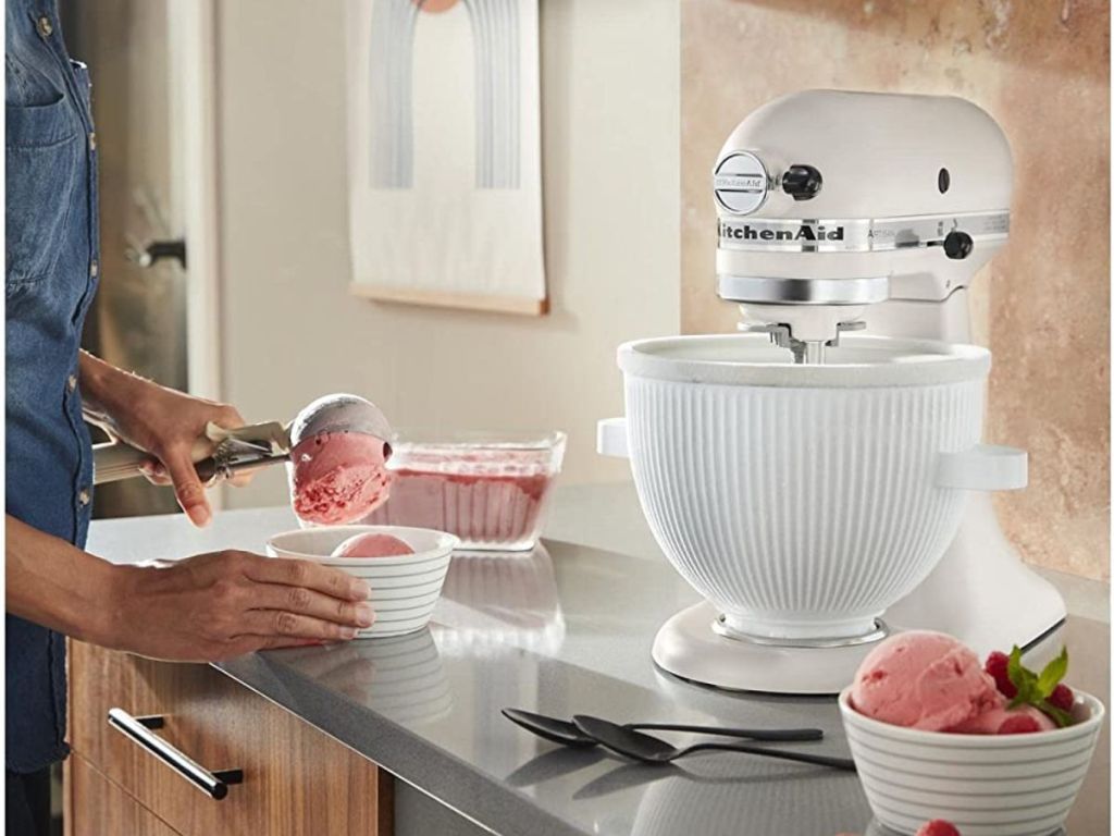 KitchenAid Ice Cream Maker Attachment shown on mixer with woman putting ice cream in a bowl