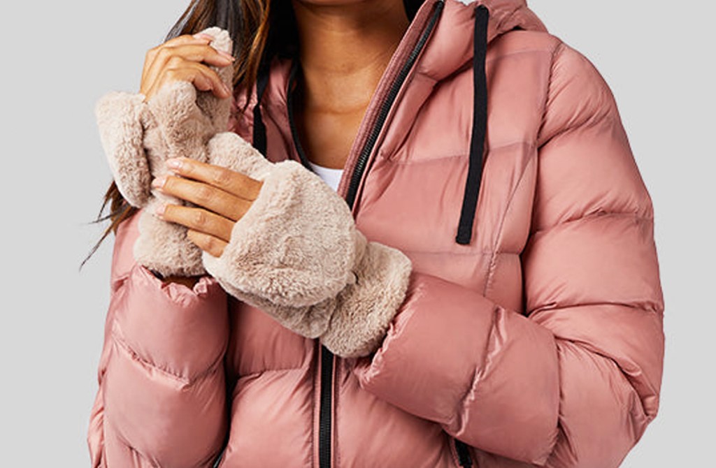 woman in pink jacket with fur flip top mittens