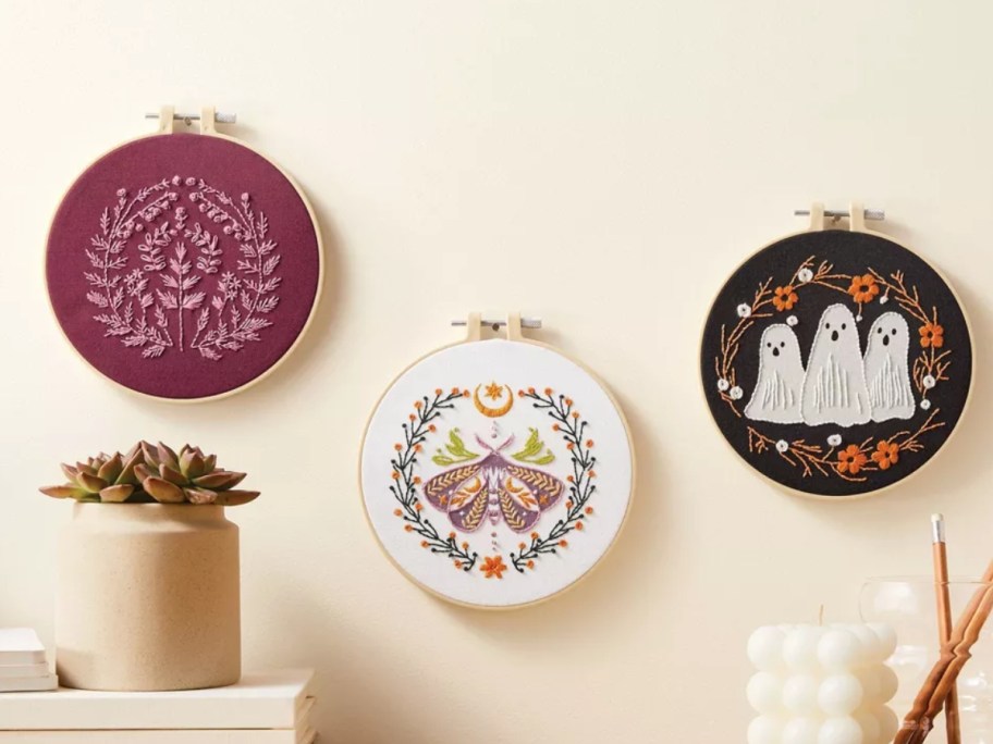 3 Halloween themed embroidery pieces on a wall