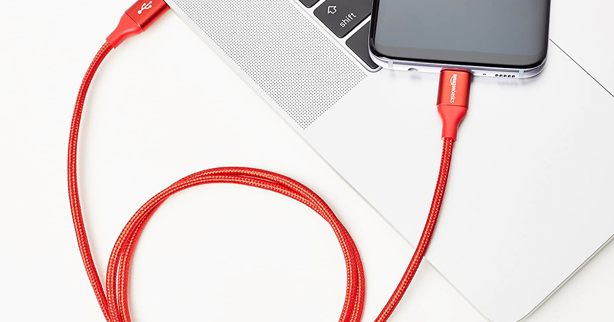 red AmazonBasics lightning cable plugged into computer and iphone