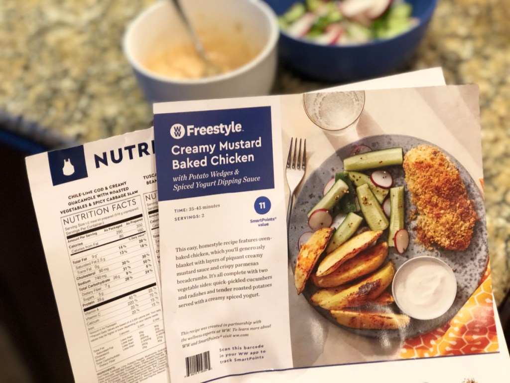 Woman holding Blue Apron Recipe Cards for a Baked Chicken Recipe