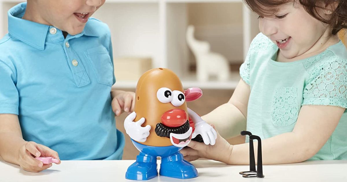 Boy and girl playing with mr potato head doll
