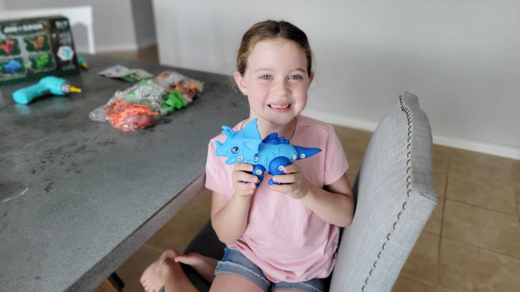 girl holding a Dinosaur STEM Toy
