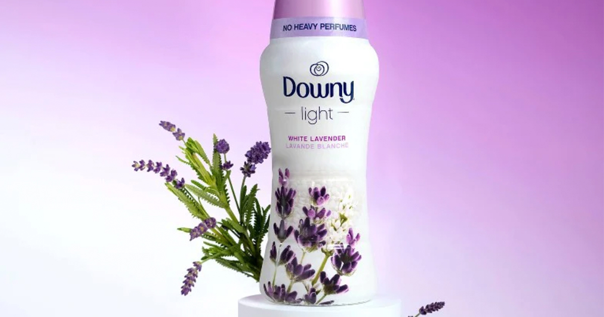 a bottle of downy light beads scent boosters with lavender flowers against an ombre purple background