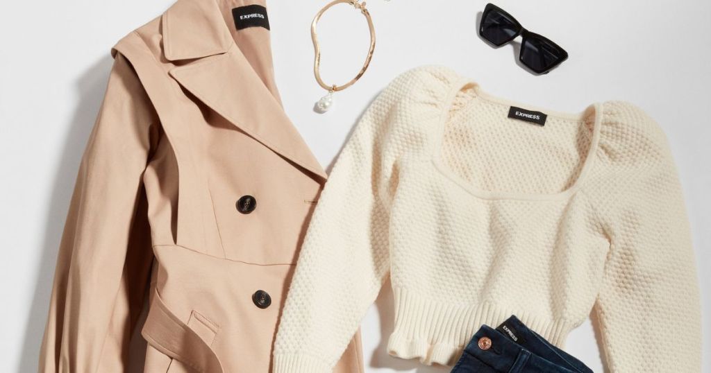 Flat lay of a women's jacket, sweater, necklace, jeans and sunglasses
