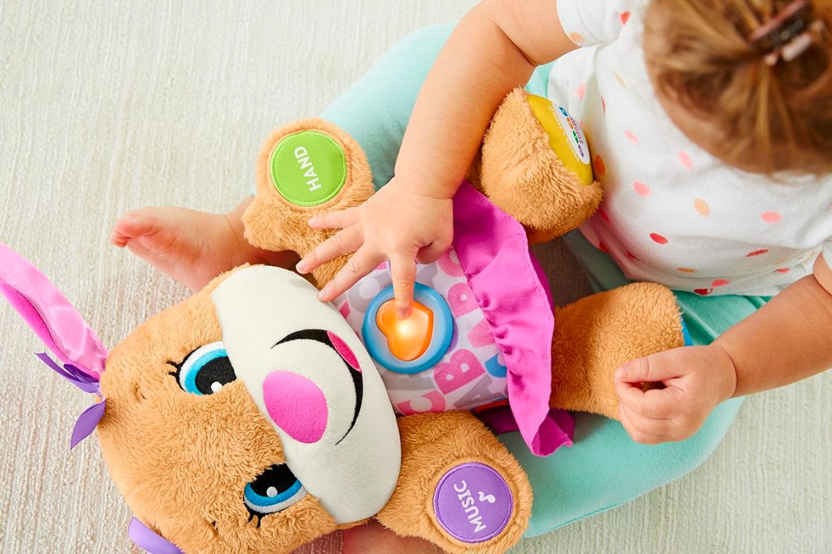 a little girl playing with a Fisher-Price Laugh Learn Smart Stages interactive Sis