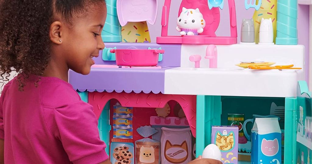 girl playing with a gabbys dollhouse playset