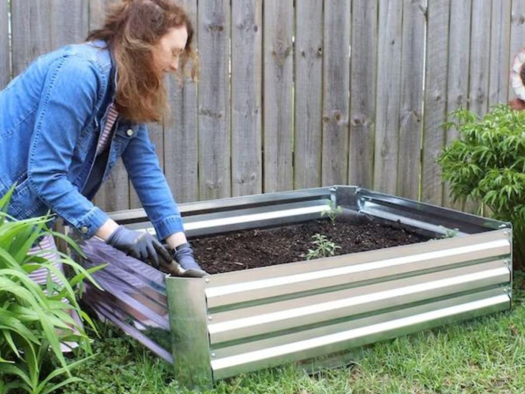 Woman planting seeds in a Galvanized Steel Raised Garden Bed