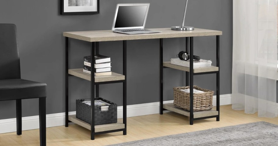 a grey wood and metal computer desk with shelves on each side, a laptop and lamp are on top