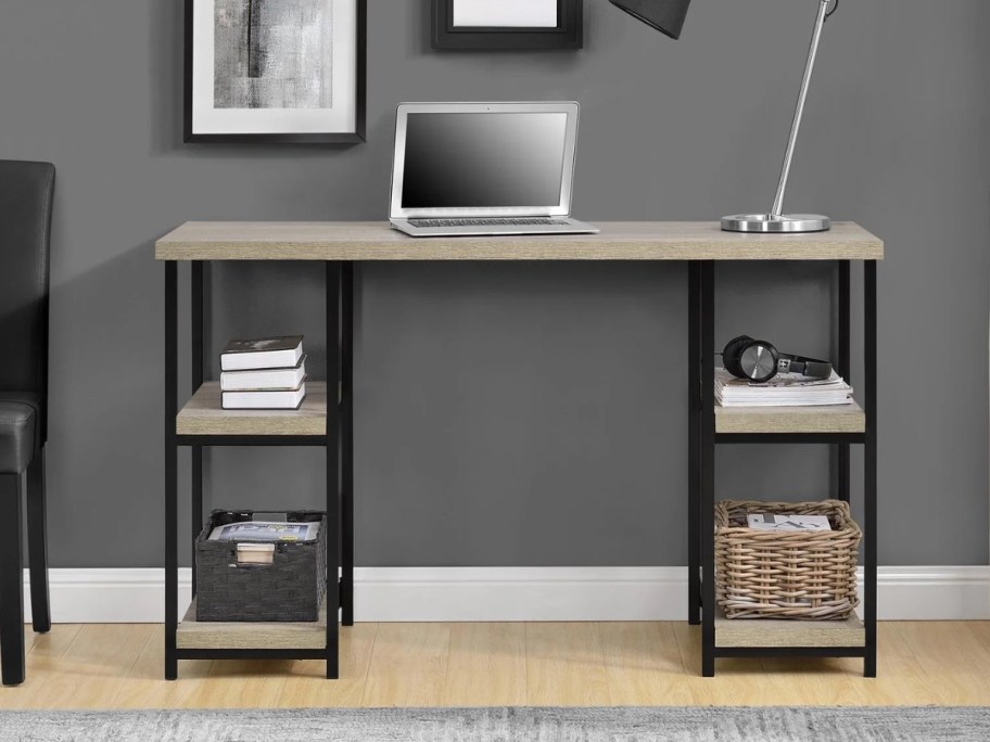 a grey wood and metal computer desk with shelves on each side, a laptop and lamp are on top