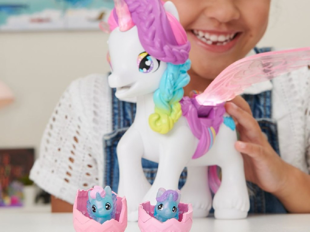 girl playing with a hatchimals colleggtible unicorn toy