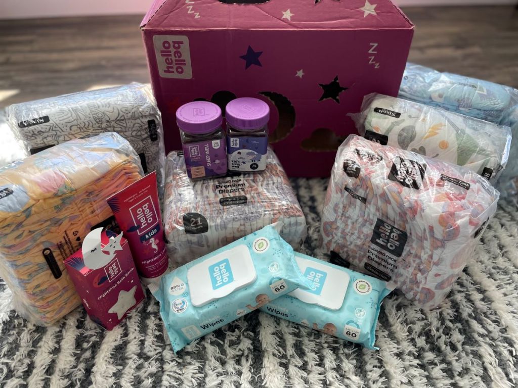 Diapers, wipes, vitamins, and bath products next to a Hello Bello box