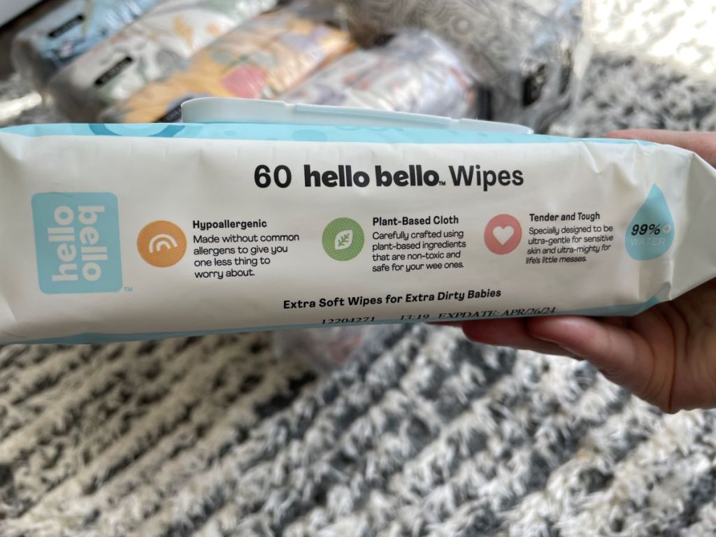 Hand holding a package of Hello Bello wipes