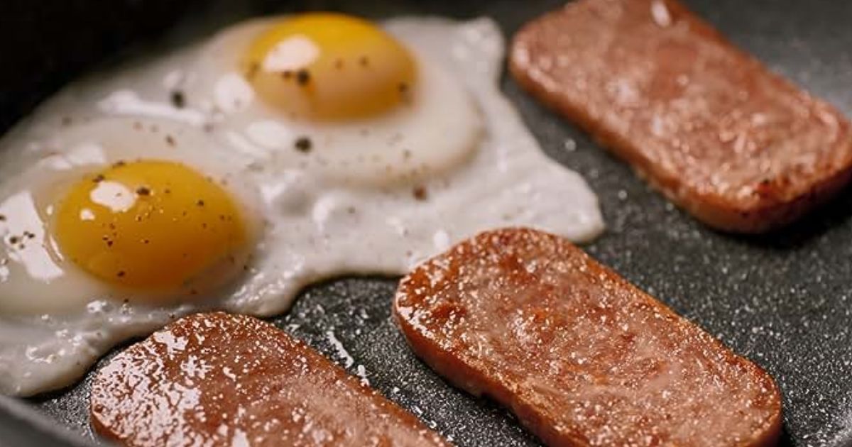Spam Slices shown in skillet with a fried egg
