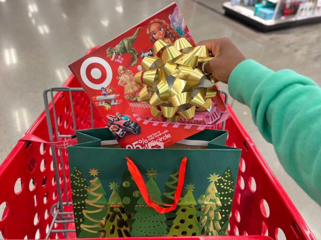 Target's 2023 Holiday Toy Catalog being dropped into a holiday gift bag