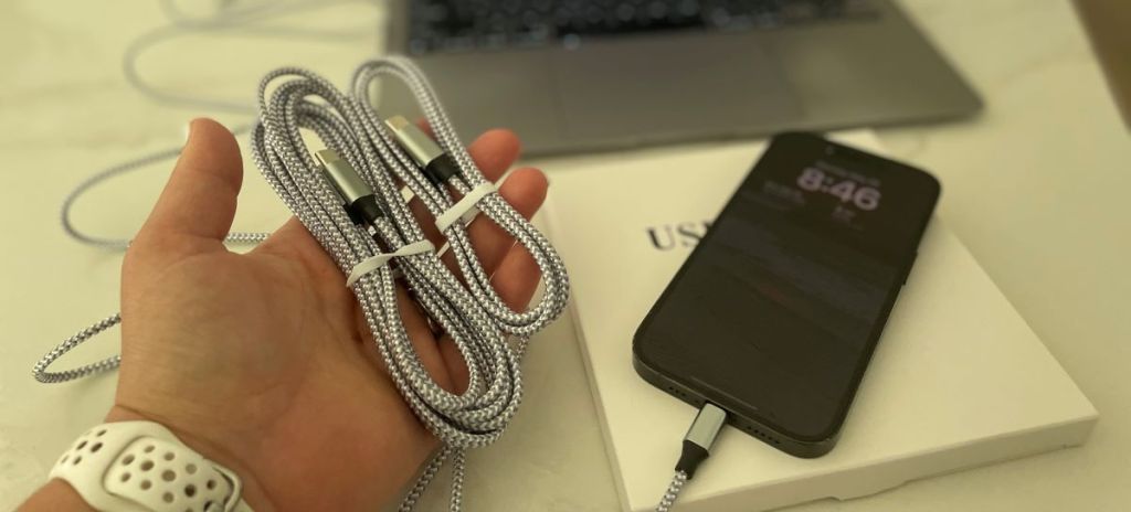 Hand holding two iPhone charging cables