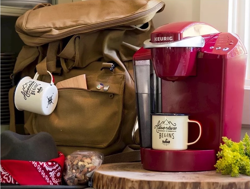 Keurig Classic with cup on it next to backpack