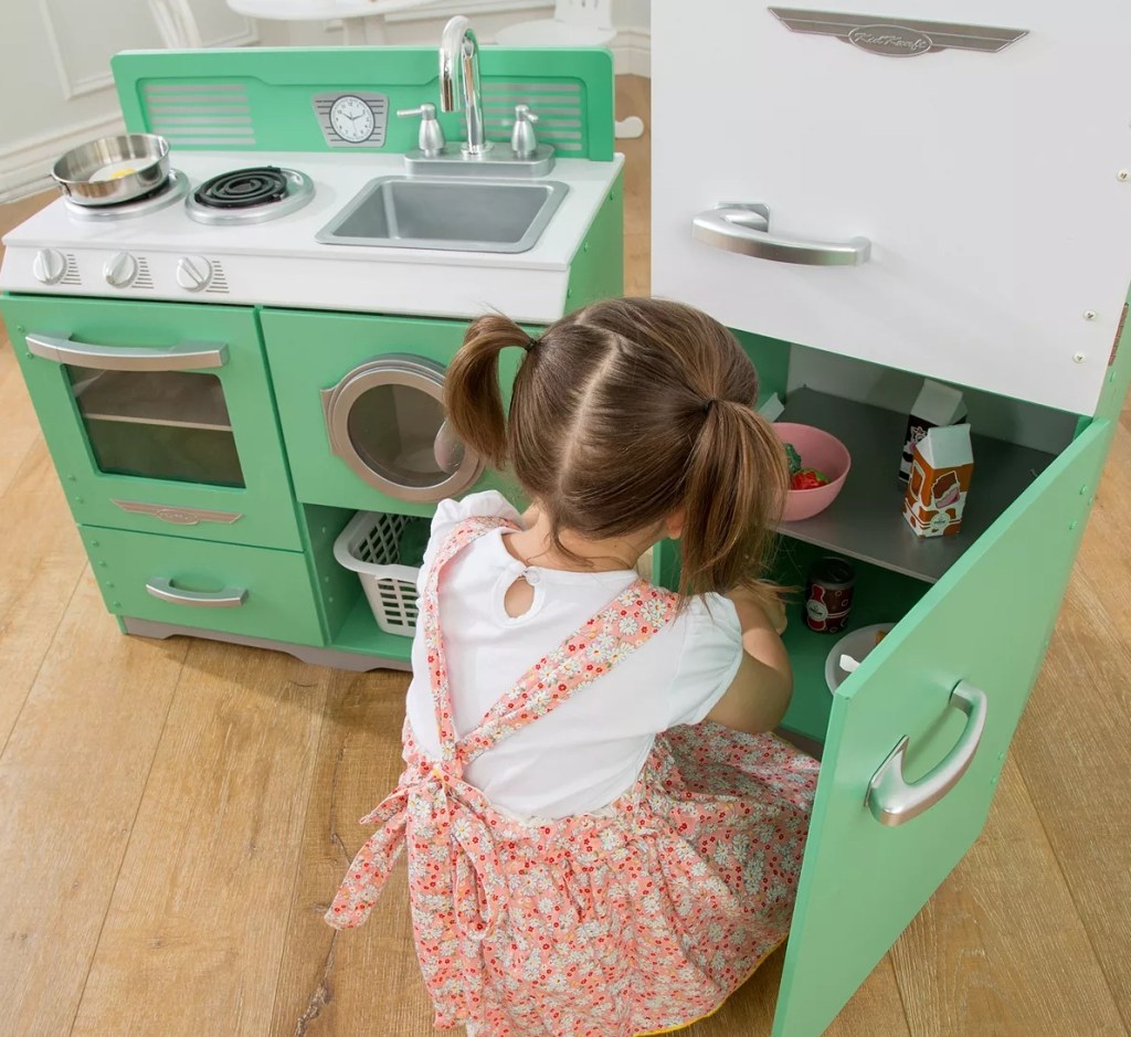 girl playing in a KidKraft Kitchen