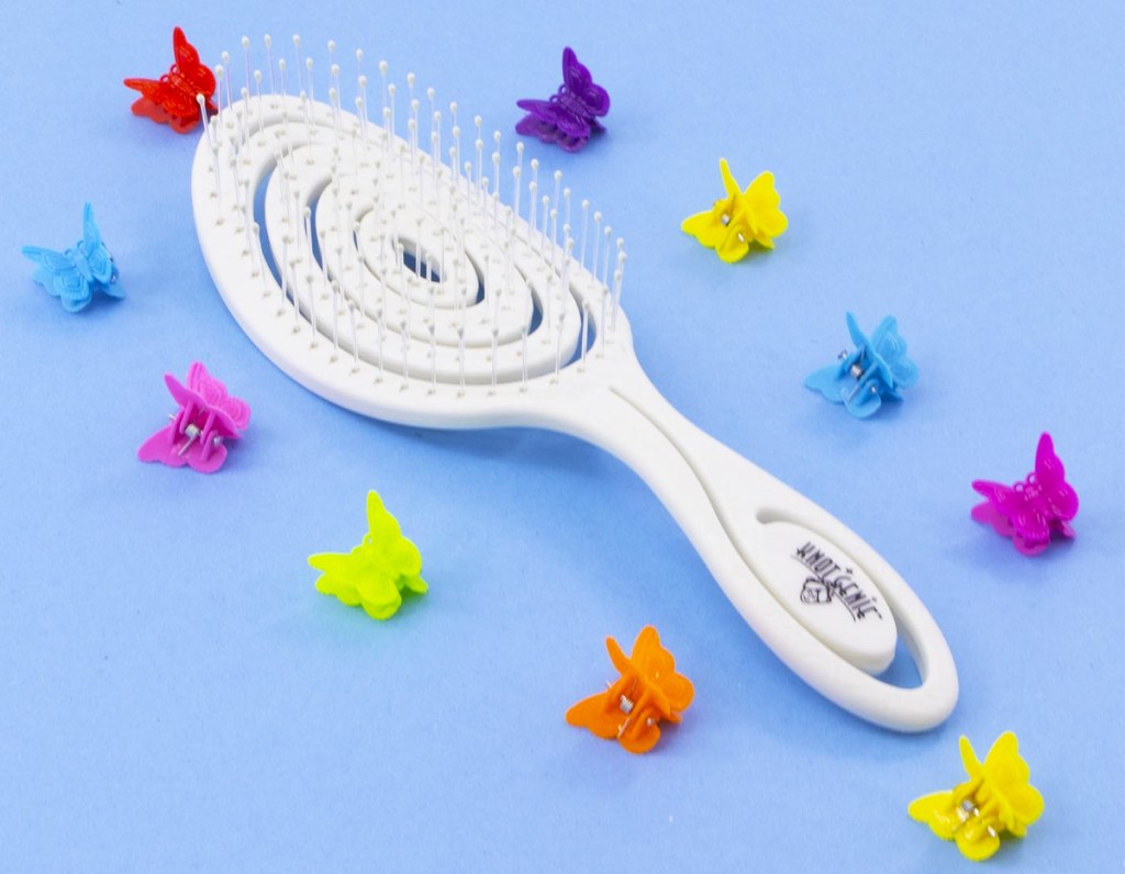 white hair brush with butterfly clips around it
