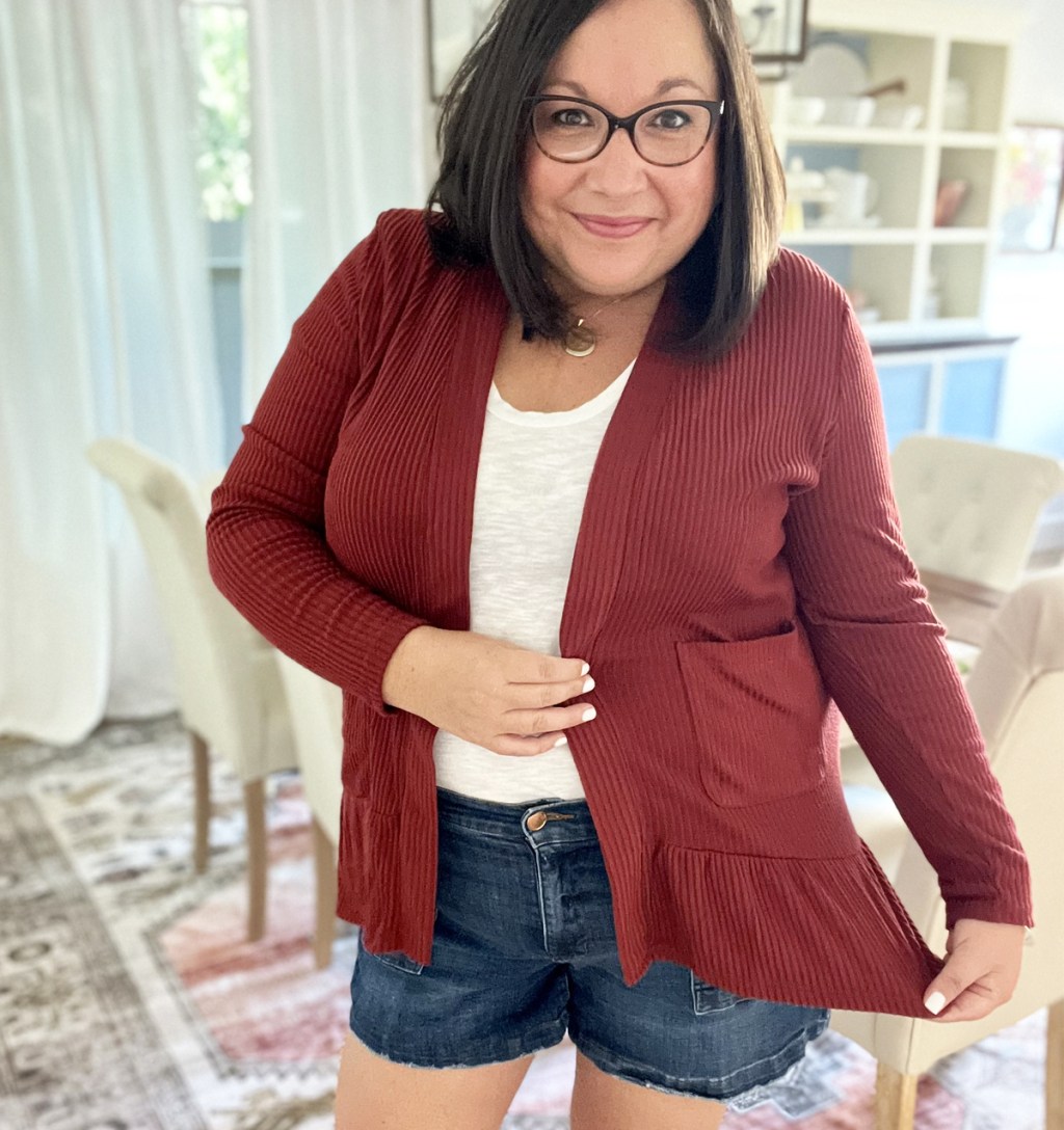 woman wearing red cardigan with white tee and denim shorts