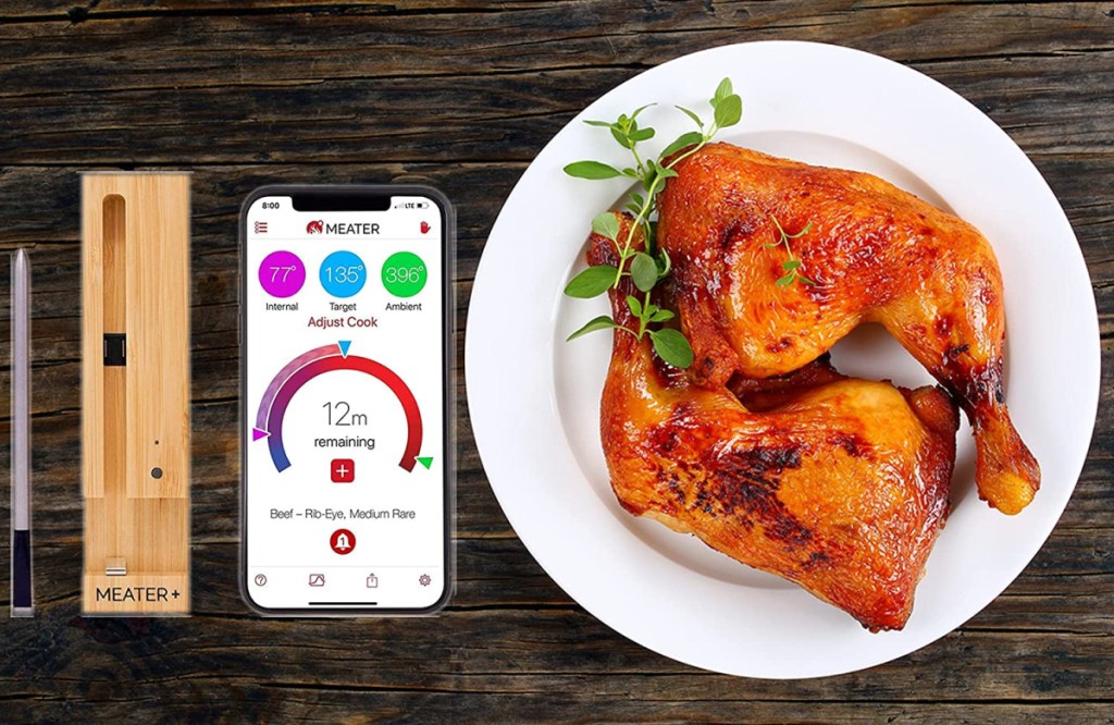 A MEATER thermometer next to phone app and perfectly cooked chicken