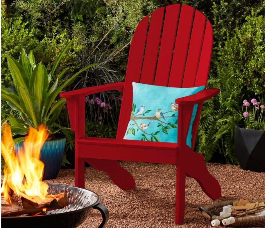 red adirondack chair with throw pillow on patio near fire pit