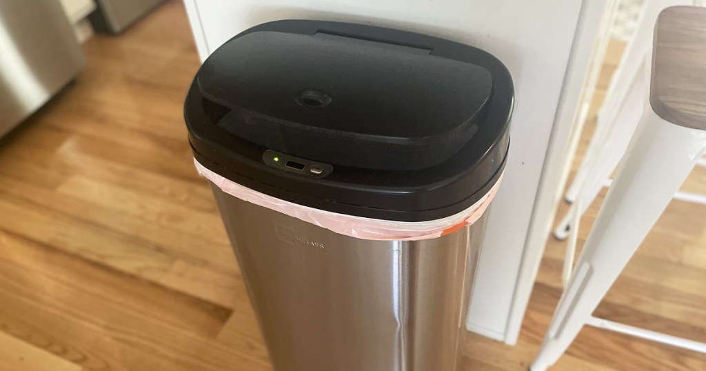 stainless steel trash can with black lid in kitchen
