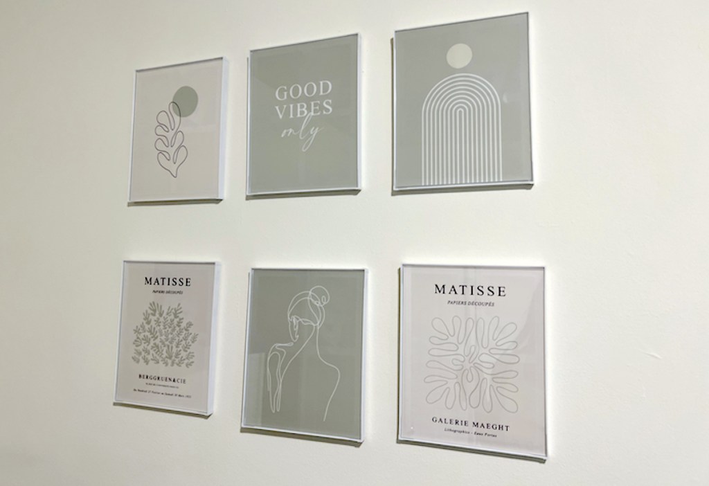 various gray and white matisse prints hanging on wall